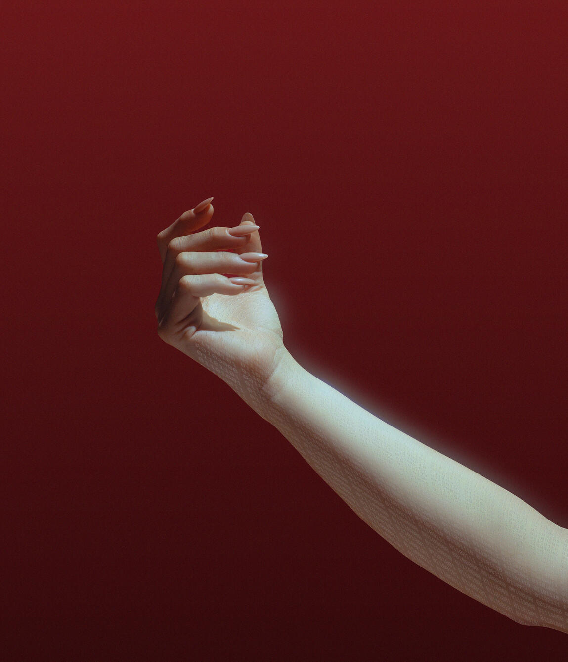 Woman's hand against a red backdrop, with binary code on her arm
